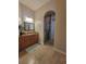 Bathroom featuring a granite counter, wood cabinets, tile flooring, a large mirror and walk-in shower at 12625 Sweet Hill Rd, Polk City, FL 33868