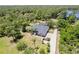 Stunning aerial view of a home with a screened-in pool, long driveway and lush greenery at 1303 Sultan Cir, Chuluota, FL 32766
