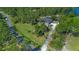 Aerial view of a house, lush landscaping, mature trees, and the long paved driveway at 1303 Sultan Cir, Chuluota, FL 32766