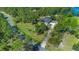 Scenic aerial view showcasing a beautiful home, mature trees, lush landscaping, and a long driveway at 1303 Sultan Cir, Chuluota, FL 32766