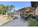 Outdoor dining area with a screened pool and patio, surrounded by lush landscaping and mature trees at 1303 Sultan Cir, Chuluota, FL 32766