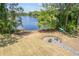 Inviting backyard with a fire pit and seating area overlooking a tranquil lake and beach at 1303 Sultan Cir, Chuluota, FL 32766