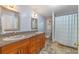 Bright bathroom features double sinks, granite countertops, wooden cabinets, and a shower and bath combo at 1303 Sultan Cir, Chuluota, FL 32766