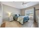 This bedroom includes a queen bed, window view, ceiling fan, and a neutral toned area rug at 1303 Sultan Cir, Chuluota, FL 32766