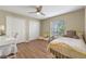 Bright bedroom features hardwood floors, ceiling fan, and natural light from a window at 1303 Sultan Cir, Chuluota, FL 32766