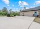 Spacious driveway leads to a three-car garage, surrounded by well-maintained landscaping and a blue front door at 1303 Sultan Cir, Chuluota, FL 32766