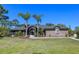 Charming brick home with manicured lawn, palm trees, and inviting screened-in entryway at 1303 Sultan Cir, Chuluota, FL 32766