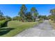 Expansive front yard with mature trees and a long driveway leading to the home at 1303 Sultan Cir, Chuluota, FL 32766