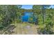 Aerial view of a lake with a seating area with chairs on the shore surrounded by lush trees at 1303 Sultan Cir, Chuluota, FL 32766