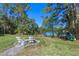 Scenic lake view with a charming seating area, featuring Adirondack chairs, nestled amidst lush trees and greenery at 1303 Sultan Cir, Chuluota, FL 32766