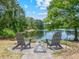 Inviting lakeside patio with Adirondack chairs and a fire pit, perfect for relaxing and enjoying the scenic view at 1303 Sultan Cir, Chuluota, FL 32766