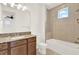 Bathroom featuring wood vanity, granite countertop, tub, shower, and neutral-colored tiles at 13169 Bromborough Dr, Orlando, FL 32832