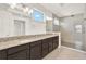 Bathroom features a granite-topped double sink vanity and a glass-enclosed shower at 13169 Bromborough Dr, Orlando, FL 32832