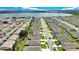 Wide aerial shot showcasing a residential street lined with similar homes, lush green lawns, and neatly parked cars at 132 Lake Smart Cir, Winter Haven, FL 33881