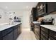 Charming kitchen features stainless steel appliances, dark cabinetry, and a stylish white countertop at 132 Lake Smart Cir, Winter Haven, FL 33881