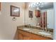 Well-lit bathroom featuring double sinks with granite countertops and a large mirror at 13209 Wild Duck Ct, Orlando, FL 32828