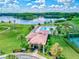 Aerial shot of a community clubhouse, with lake view, manicured landscape and tennis courts, setting the scene for luxury living at 13209 Wild Duck Ct, Orlando, FL 32828