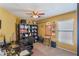 A home office featuring a ceiling fan, computer desk, bookshelf, and a window for natural light at 13209 Wild Duck Ct, Orlando, FL 32828