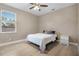 Cozy bedroom featuring a large window, ceiling fan, and light wood floors at 13330 Meergate Cir, Orlando, FL 32837