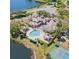 Stunning aerial view of house with pool, cabana, and tennis courts next to a lake at 13941 Fairway Island Dr # 733, Orlando, FL 32837