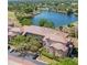 Aerial view of a brick condominium community overlooking a serene lake with lush landscaping at 13941 Fairway Island Dr # 733, Orlando, FL 32837