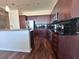 Modern kitchen with stainless steel appliances, black subway tile backsplash, and dark wood cabinetry and floors at 155 S Court Ave # 2904-Penthouse, Orlando, FL 32801