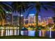 City skyline at night reflects vibrant lights over tranquil lake water, framed by palm trees at 155 S Court Ave # 2904-Penthouse, Orlando, FL 32801