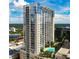 High-rise building with glass windows, balconies, and a pool area, under a bright blue sky at 155 S Court Ave # 2904-Penthouse, Orlando, FL 32801