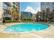 Community outdoor swimming pool surrounded by lounge chairs and lush landscaping at 155 S Court Ave # 2904-Penthouse, Orlando, FL 32801