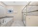 Bright bathroom featuring a soaking tub and a separate glass-enclosed shower with marble accents at 1585 Plunker, Davenport, FL 33896