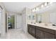 Bathroom featuring double vanity with dark cabinets and marble flooring at 1585 Plunker, Davenport, FL 33896