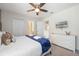 Clean bedroom with white dresser, TV, neutral walls, and a comfortable bed with a blue blanket at 1585 Plunker, Davenport, FL 33896