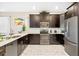 Well-lit kitchen with stainless steel appliances, dark cabinets, and quartz countertops at 1585 Plunker, Davenport, FL 33896