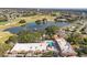 Gorgeous aerial view showcases golf course with serene lake and clubhouse pool at 1765 W Schwartz Blvd, Lady Lake, FL 32159