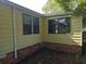 Exterior corner with large windows and brick foundation surrounded by mulch at 1765 W Schwartz Blvd, Lady Lake, FL 32159