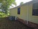 Side view of a well maintained single story home showing the siding and brick foundation at 1765 W Schwartz Blvd, Lady Lake, FL 32159