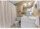 Cozy bathroom showcasing white cabinets, tiled floors, shower with white curtain, and natural light at 1801 Chamberlin St, Orlando, FL 32806