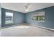 Large, sun-filled bedroom with neutral carpet, multiple windows, and blue accent walls at 1801 Chamberlin St, Orlando, FL 32806