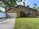 Charming single-story home featuring a well-maintained lawn and a two car garage with a concrete driveway at 1801 Chamberlin St, Orlando, FL 32806