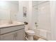 Bright bathroom with tile floors, gray cabinets, modern fixtures, and a shower/tub combination at 1908 Perch Hammock Loop, Groveland, FL 34736