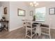 Cozy dining area with white table set, modern light fixture, and a large window at 1908 Perch Hammock Loop, Groveland, FL 34736