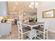 Open concept eat-in kitchen with white table set, modern light fixture, and stainless steel appliances at 1908 Perch Hammock Loop, Groveland, FL 34736