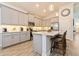 Modern kitchen featuring gray cabinetry, stainless steel appliances, and a center island with a breakfast bar at 1908 Perch Hammock Loop, Groveland, FL 34736