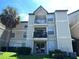 Three-story condo featuring balconies, sliding glass door, and mature palm tree at 1932 Lake Atriums Cir # 77, Orlando, FL 32839