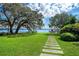 Manicured backyard with waterfront view, leading to a private dock and serene water access at 2010 Hoffner Ave, Belle Isle, FL 32809