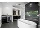 Modern bathroom featuring a sleek tub, black cabinets, a window, and a glass-enclosed shower at 2010 Hoffner Ave, Belle Isle, FL 32809