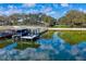 A private dock and boat lift on a pristine lake provide an idyllic setting for waterfront living at 2010 Hoffner Ave, Belle Isle, FL 32809