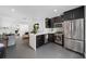 Open-concept kitchen featuring stainless steel appliances, breakfast bar, and seamless flow to the living area at 2010 Hoffner Ave, Belle Isle, FL 32809