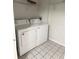 Laundry room with white washer and dryer units and overhead storage at 2013 Tizewell Cir # 1408, Orlando, FL 32837