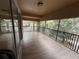 Wide, covered balcony with wood-look flooring and a black metal railing provides outdoor enjoyment at 2511 Metro Sevilla Dr # 101, Orlando, FL 32835